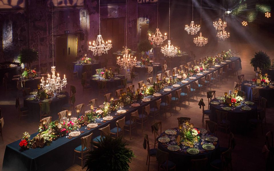 Seated Dinner at BAC - Credit: Ben Phillips The Grand Hall with table setup for an event, with one very long table ornately decorated, plus chandeliers hanging from the ceiling.