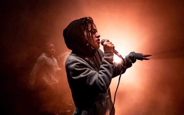 Beatbox performer lit with warm lighting holding a microphone