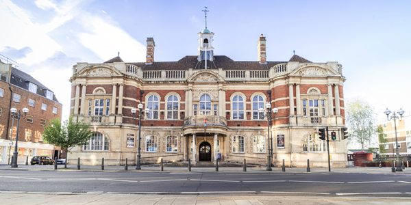 The exterior of Battersea Arts Centre from across the street. A large Victorian building with arched windows and a weather vane on its roof.